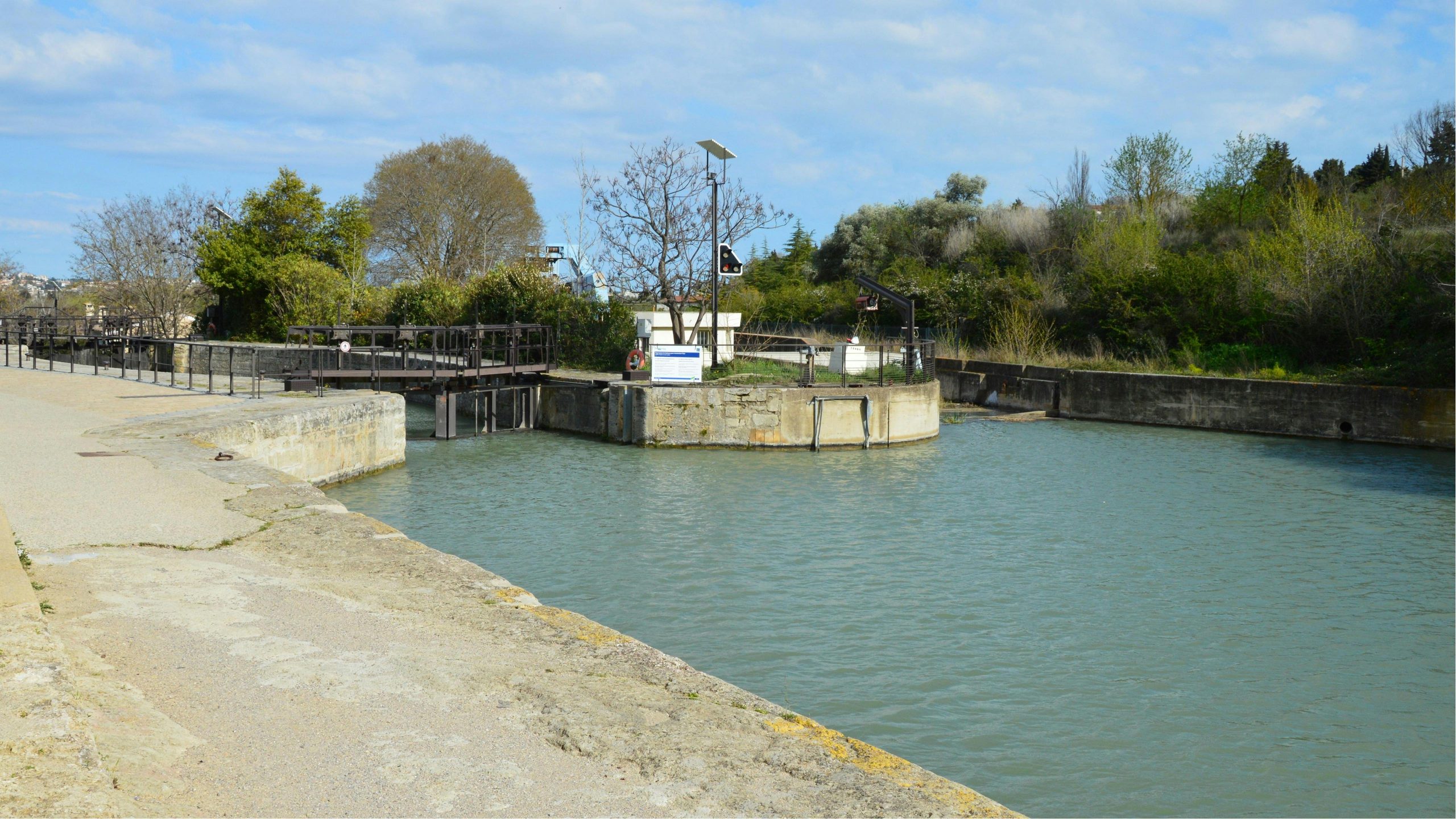Vue panoramique des écluses du canal de Béziers, en France, avec de la verdure et un ciel bleu par une journée ensoleillée.