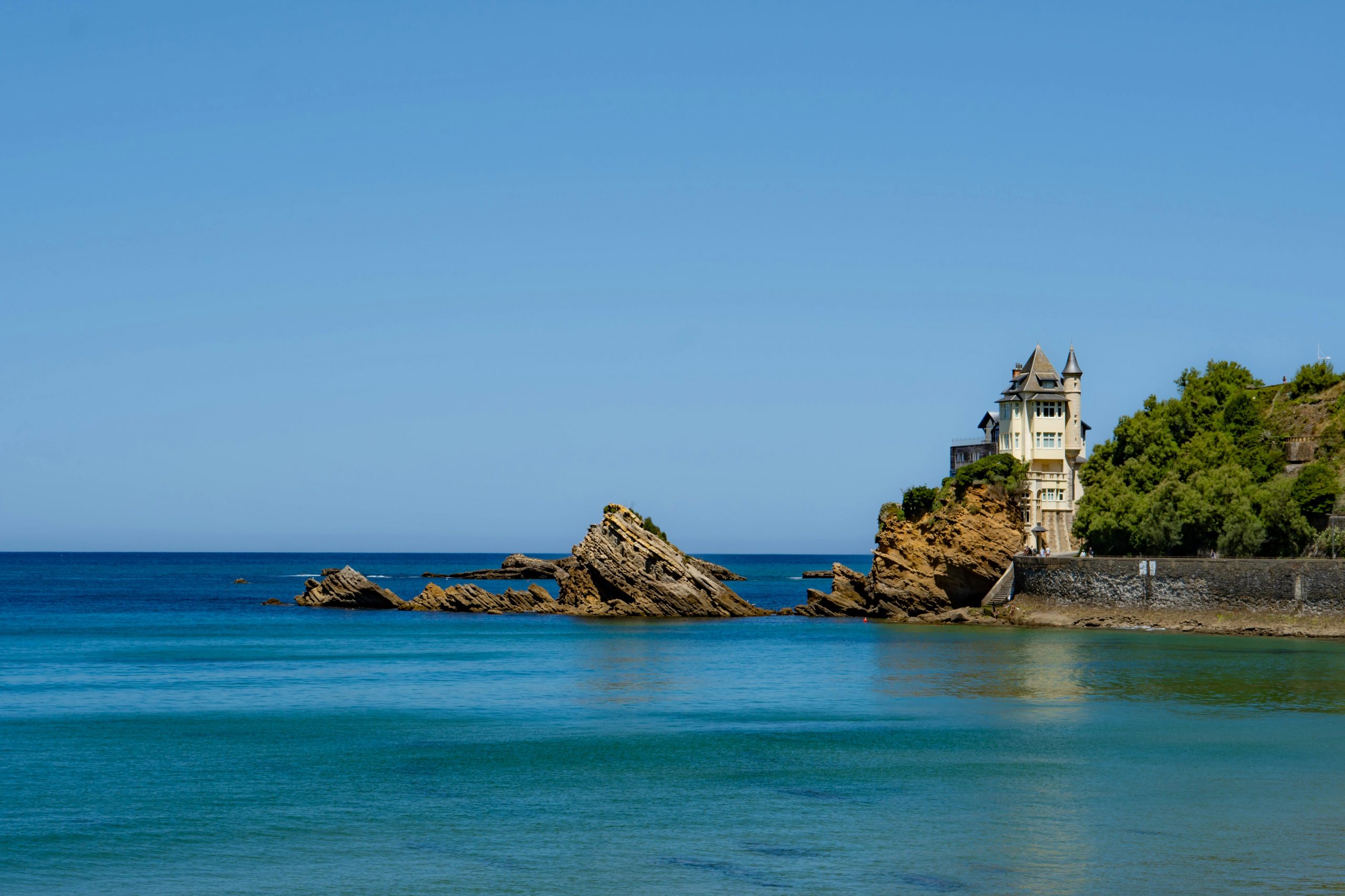 Superbe cliché de la Villa Belza sur la côte rocheuse de Biarritz, en France, sous un ciel bleu clair.