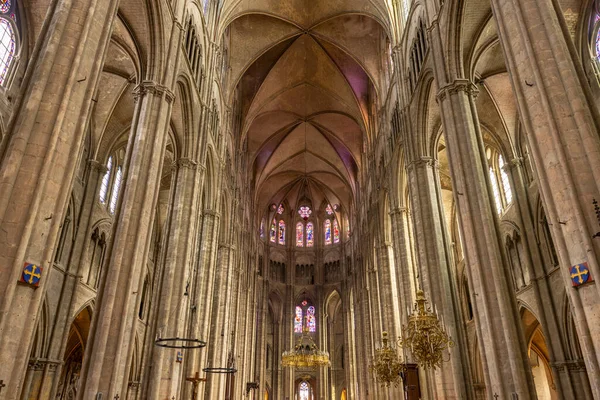 Vue de l'intérieur de la nef de la cathédrale de Bourges, France, avec ses hautes arches et ses vitraux.