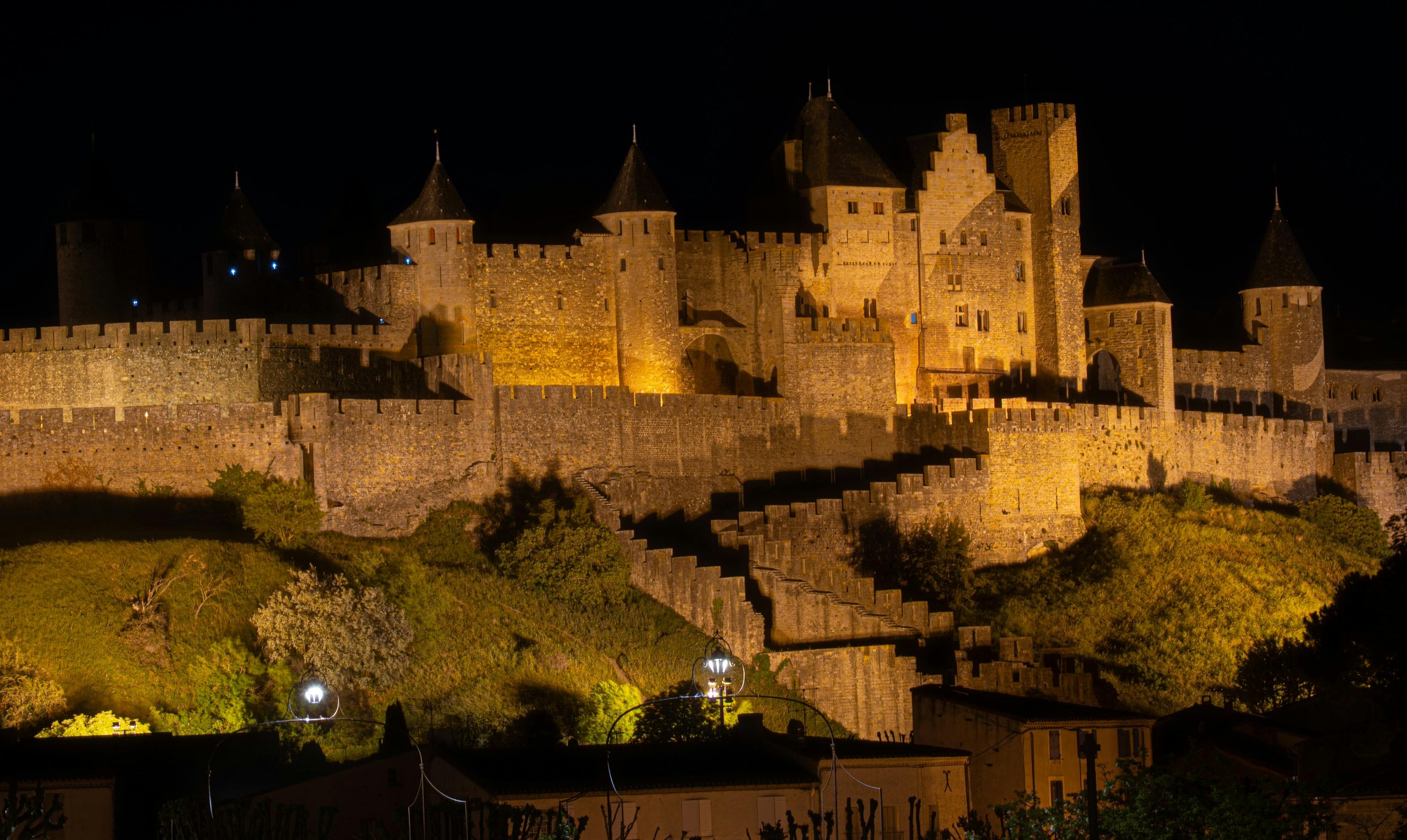 Vue nocturne majestueuse de la Citadelle de Carcassonne, magnifiquement illuminée.
