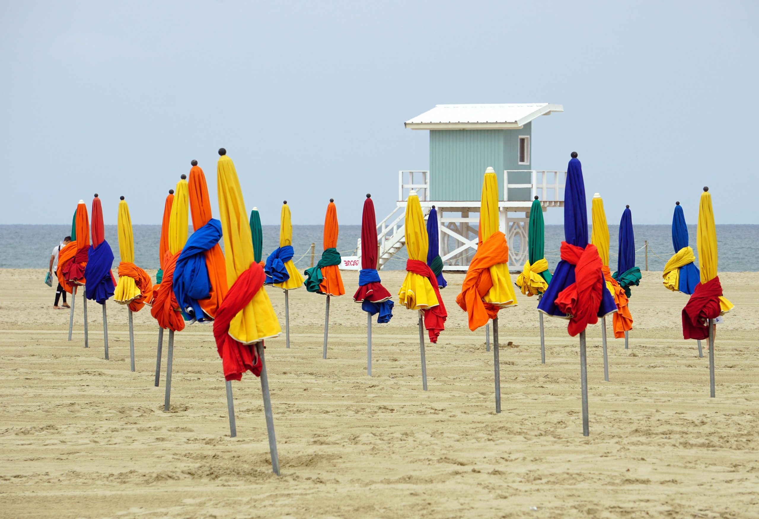 Parasols de plage vibrants sur la plage de Deauville en Normandie, France, avec un paysage marin tranquille.