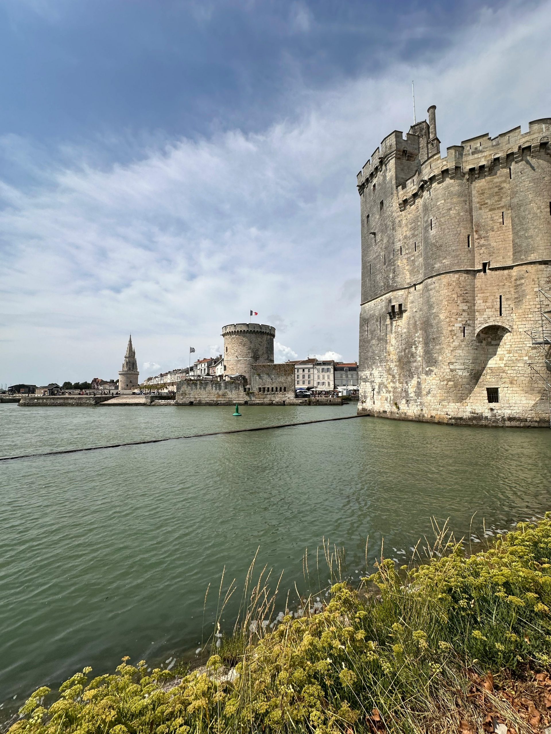 Vue spectaculaire des tours du port historique de La Rochelle contre un ciel nuageux.