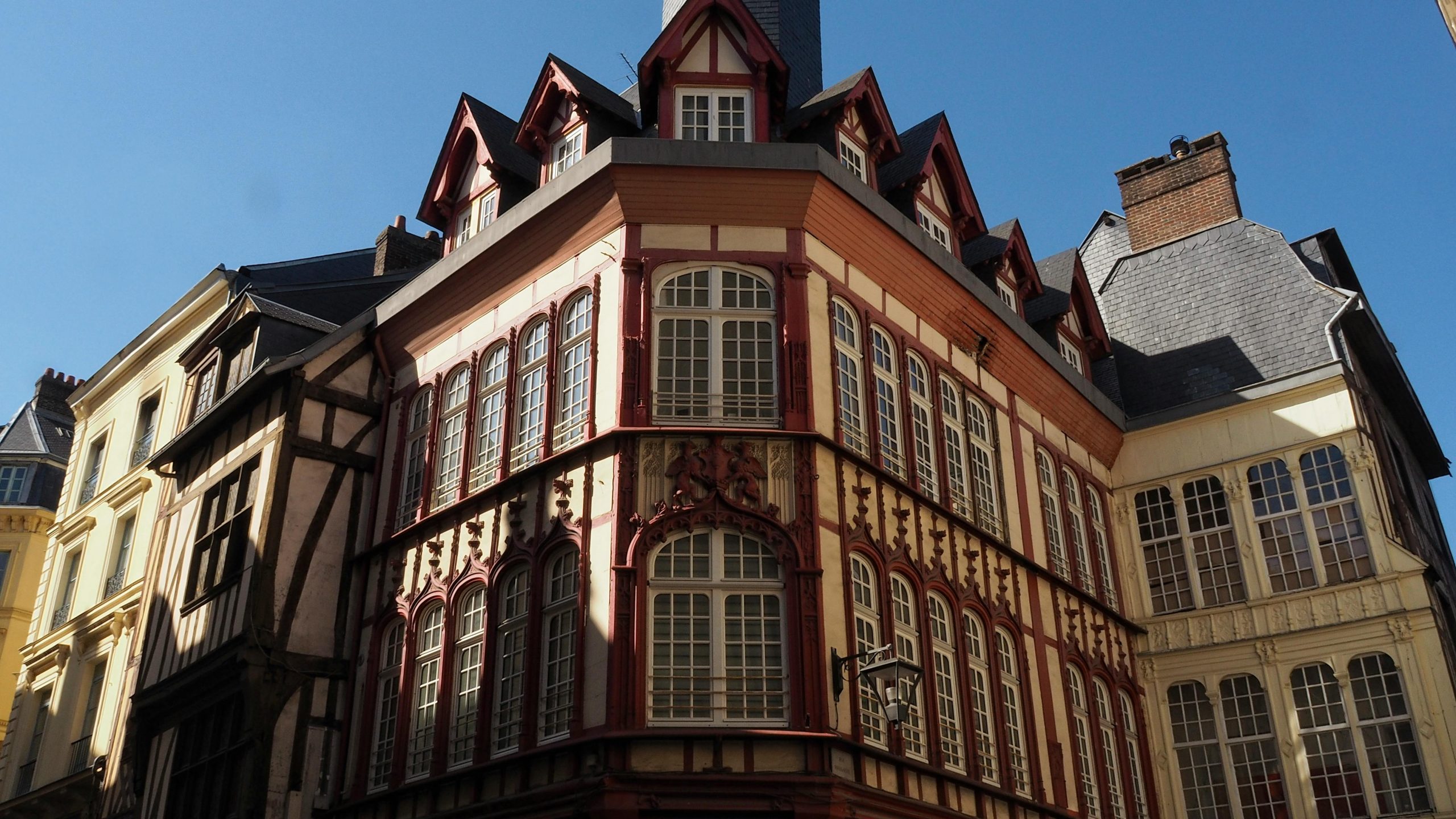 Bâtiments historiques à colombages à Rouen, mettant en valeur l'architecture médiévale et la lumière du soleil